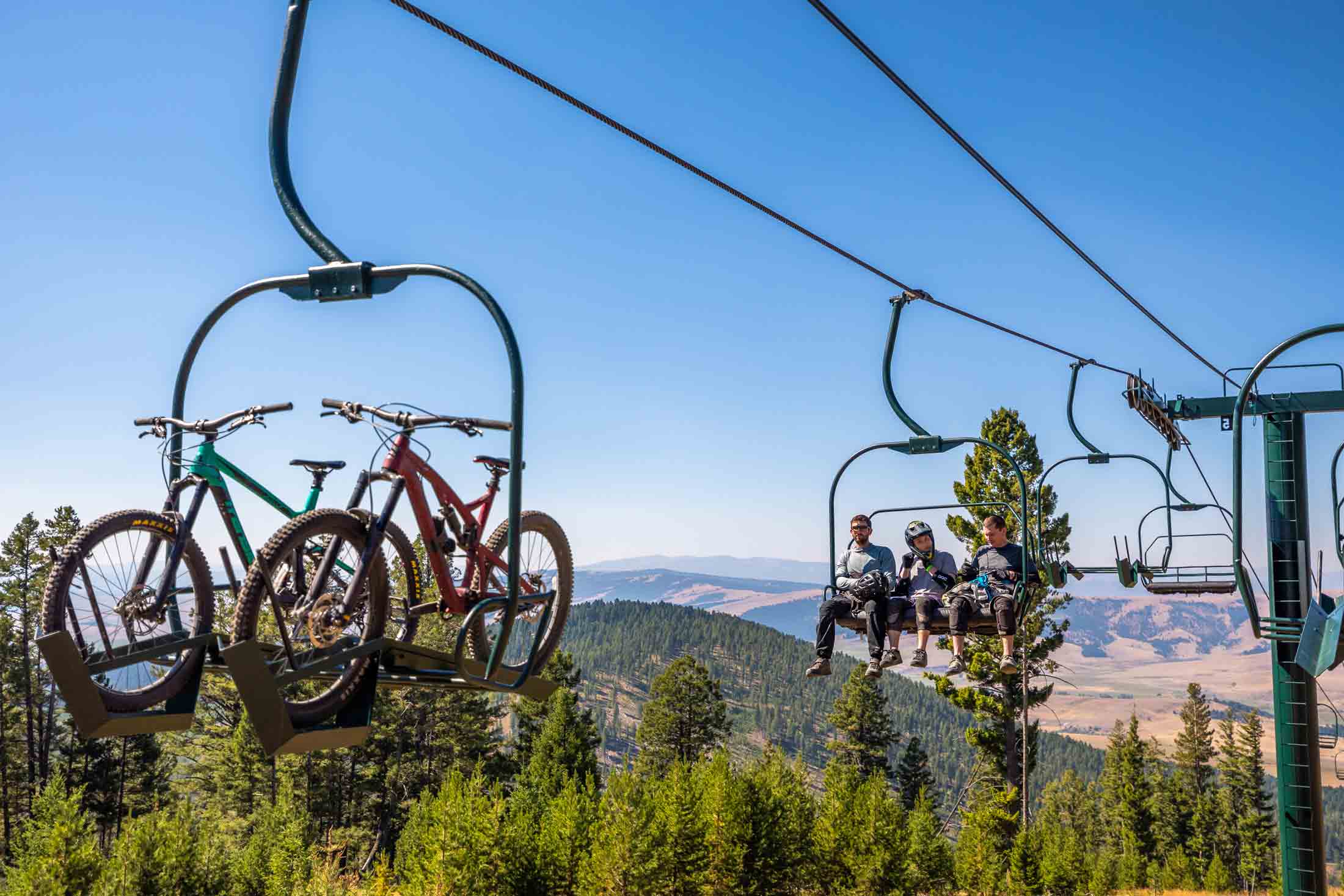 Cyclists on a lift with their mountain bikes at Discovery Bike Park in Philipsburg, Montana.